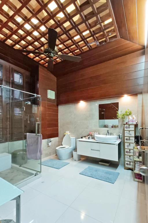 Spacious modern bathroom with wooden accents and glass shower