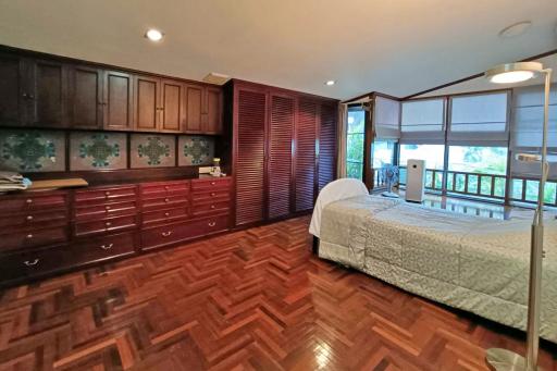 Spacious bedroom with hardwood floors and large windows