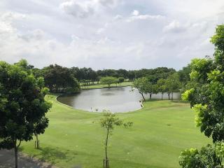 Scenic view of a lush green park with a pond