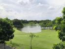 Scenic view of a lush green park with a pond