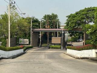 Gated community entrance with lush greenery and security