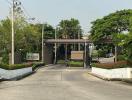 Gated community entrance with lush greenery and security