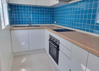 Modern kitchen with blue tile backsplash and wooden countertops