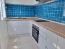 Modern kitchen with blue tile backsplash and wooden countertops