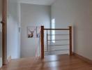 Spacious hallway with hardwood flooring and modern railing