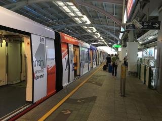 Subway train stopped at a modern urban station with passengers waiting to board