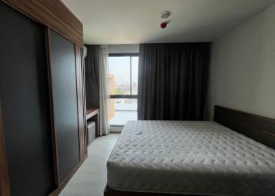 Modern bedroom with a large window and dark curtains