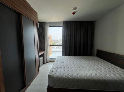 Modern bedroom with a large window and dark curtains