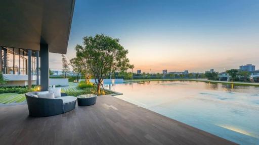 Modern home exterior with pool and seating area at dusk