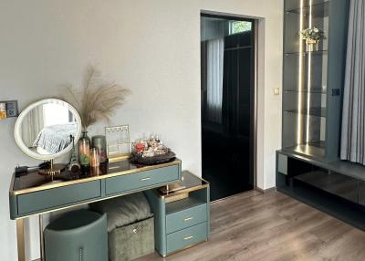 Stylish bedroom interior with a modern vanity table, elegant lighting, and air conditioning