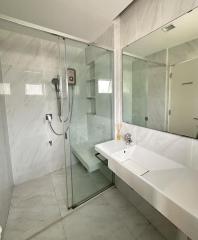 Modern bathroom interior with glass shower and white sink