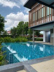 Luxurious outdoor swimming pool with adjacent building and natural landscape