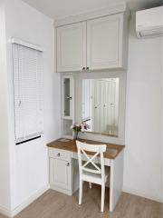 Cozy well-lit corner kitchen with white cabinetry and modern appliances