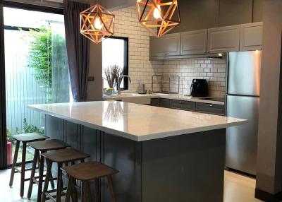 Modern kitchen with central island and designer pendant lights