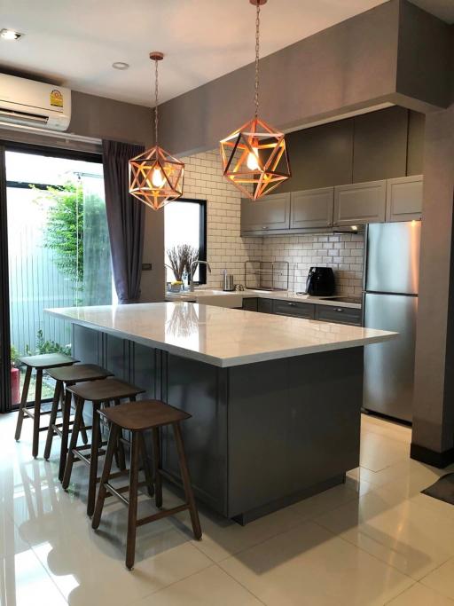 Modern kitchen with central island and designer pendant lights