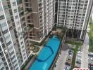 High-rise residential buildings with a swimming pool and parking lot