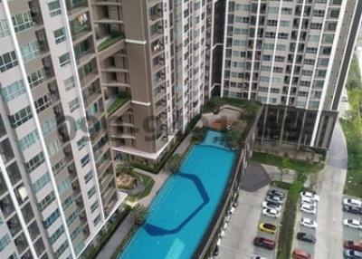 High-rise residential building with outdoor swimming pool and parking area