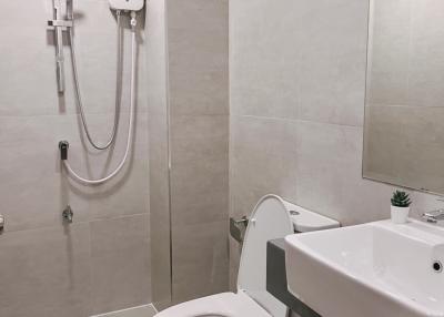 Modern bathroom interior with wall-mounted sink and toilet with a shower system