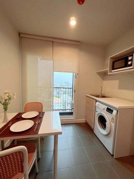 Compact kitchen with dining area, modern appliances, and balcony access