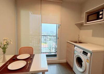Compact kitchen with dining area, modern appliances, and balcony access