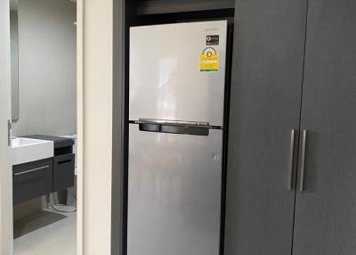 Modern kitchen with stainless steel refrigerator and dark cabinets