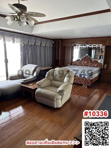 Spacious bedroom with wood-paneled walls and hardwood flooring