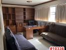 Home office with a large desk, bookshelf, and sofa