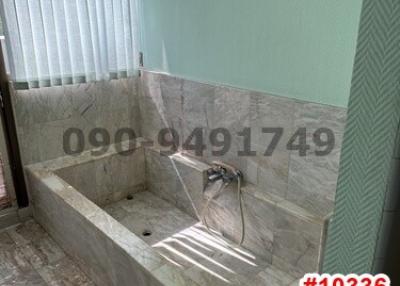 Compact bathroom with built-in tub and hand shower