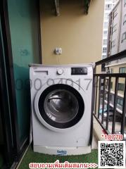 Washing machine on a small apartment balcony with buildings in the background