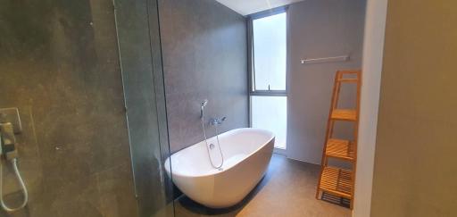 Modern bathroom with a freestanding tub, walk-in shower, and a large window