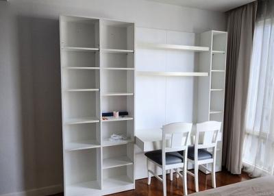 Spacious bedroom with shelving unit and dining area