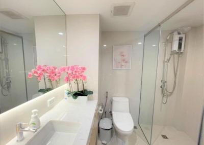 Modern bathroom interior with glass shower and floral decoration