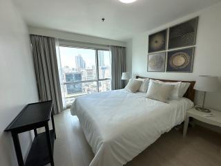 Modern bedroom with a large window overlooking the city