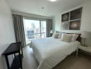 Modern bedroom with a large window overlooking the city