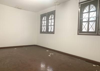 Spacious empty room with brown floor and white walls