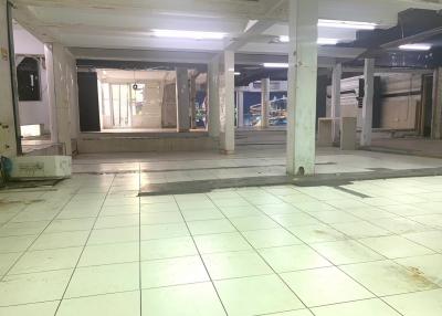 Spacious empty interior of a commercial building with tiled floors and pillars