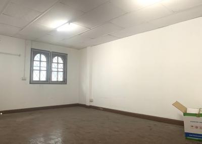 Spacious empty room with white walls and arched window