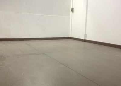 Empty room with white walls and concrete flooring