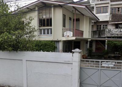 Two-story residential home with white walls and a gray gate