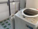 Compact laundry room with modern washing machine and built-in storage