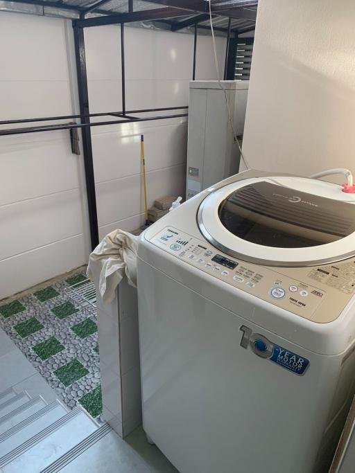 Compact laundry room with modern washing machine and built-in storage