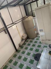 Utility area with storage tank and tiled flooring