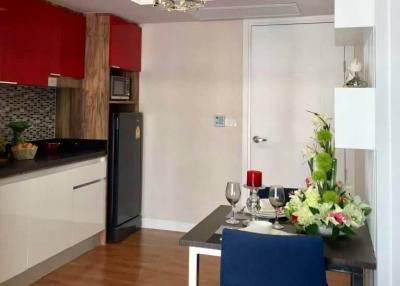 Modern kitchen with dining area featuring elegant flower decoration and red accents