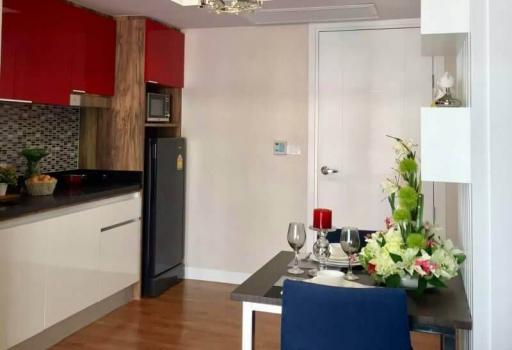 Modern kitchen with dining area featuring elegant flower decoration and red accents