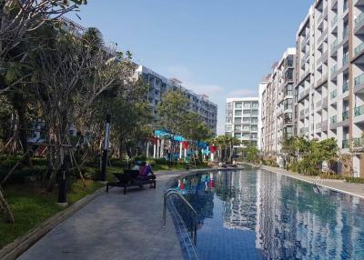 Modern apartment complex with residents enjoying amenities near a communal pool