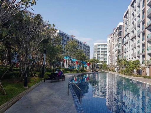 Modern apartment complex with residents enjoying amenities near a communal pool