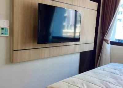 Modern bedroom interior with wall-mounted TV