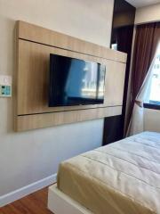 Modern bedroom interior with wall-mounted TV