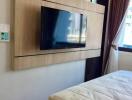 Modern bedroom interior with wall-mounted TV