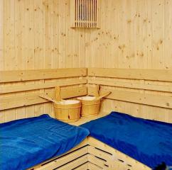 Cozy wooden sauna room with blue towels and traditional sauna accessories